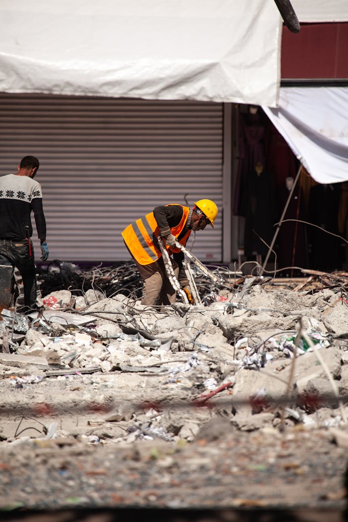 our-services-1 Workers in reflective vests clear debris from earthquake damage in Malatya, Türkiye.